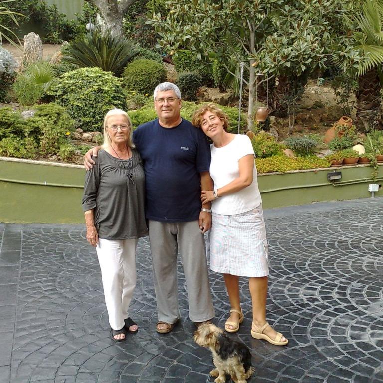 Eine glückliche Familie posiert mit einem Hund inmitten eines üppigen, grünen Gartens.