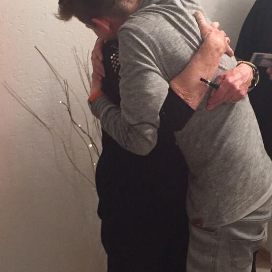 Zwei Männer umarmen sich fest in einer Innenaufnahme.