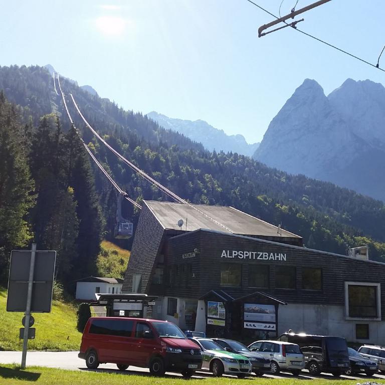 Eine Seilbahnstation in einer grünen Almlandschaft mit Blick auf majestätische Alpenberge.