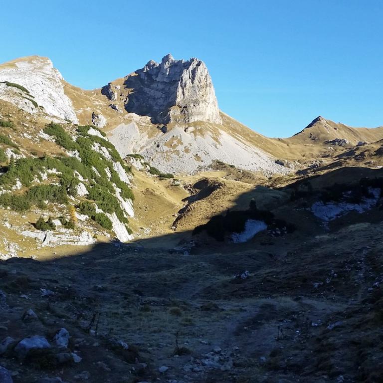 Panoramaaufnahme steiler, felsiger Berge unter klarem blauem Himmel