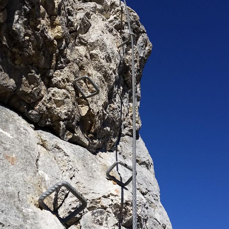 Kletterausrüstung an einer Felswand vor blauem Himmel