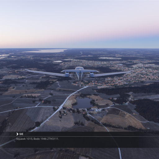 Ein Flugzeug fliegt über eine ausgedehnte, ländliche Landschaft während der Dämmerung.